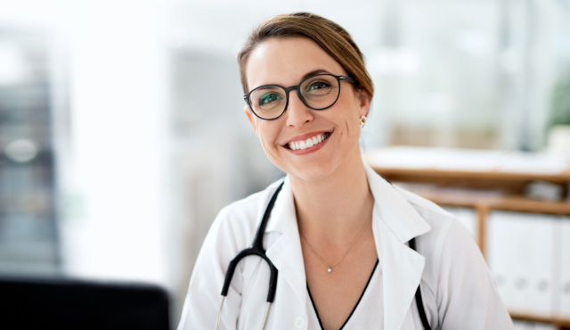 Firmenvertragsrecht für Ärzte: lächelnde Ärztin blickt in Kamera