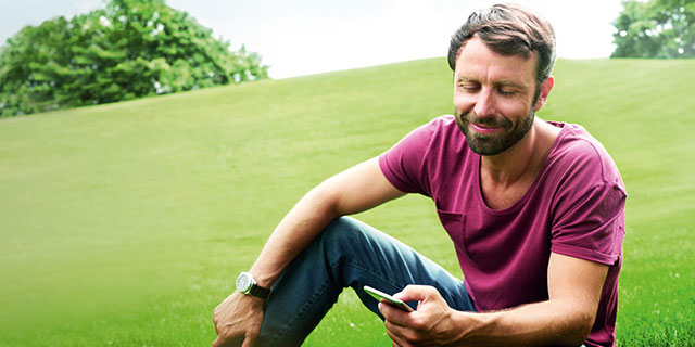 Mann informiert sich mit Handy über Gesundheit App für ÖVB-Kunden.