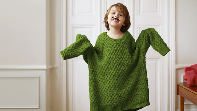 ÖVB Nachwuchsförderung: ein kleiner Junge hat einen grünen viel zu großen Pullover an